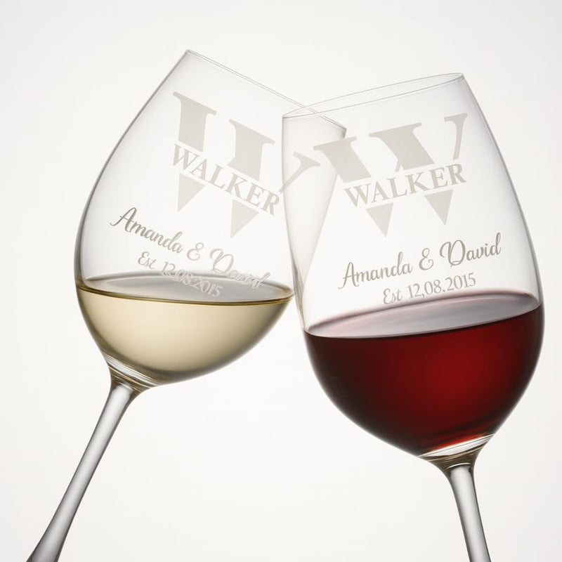 Two personalized wine glasses with names and date engraved on a white background