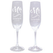 Two personalized champagne flutes with 'Mr.' and 'Mrs.' engraved on a white background.