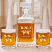 Personalized whiskey decanter and glasses with 'TONY WILSON' engraving on a neutral background.