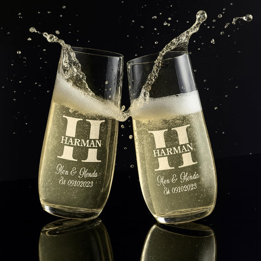 Two champagne flutes with 'HARMAN' branding and personalized text on a black background.
