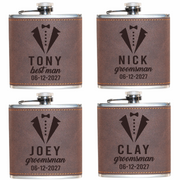 Four personalized flasks with tuxedo design and names engraved on a white background