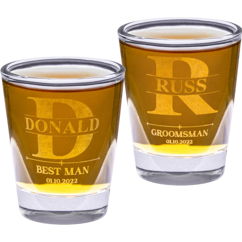 Two shot glasses with engraved names and dates on a white background